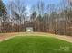 Backyard featuring manicured lawn, shed, and surrounding trees at 121 Purple Finch Ln, Mooresville, NC 28117