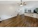 An expansive living room leads into the kitchen, showcasing hardwood floors and a vaulted ceiling complete with a ceiling fan at 121 Purple Finch Ln, Mooresville, NC 28117