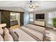A serene main bedroom featuring a sliding barn door to the bathroom, a ceiling fan, and a large window for natural light at 121 Purple Finch Ln, Mooresville, NC 28117