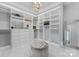 Spacious walk-in closet with custom shelving, drawers, and a central ottoman at 19329 Watermark Dr # 551/552, Cornelius, NC 28031