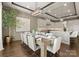 A dining room with a long wooden table set for a meal, complemented by elegant chairs and a modern chandelier at 19329 Watermark Dr # 551/552, Cornelius, NC 28031