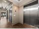 Hallway with an elevator, wooden floors, and modern sconce lighting at 19329 Watermark Dr # 551/552, Cornelius, NC 28031