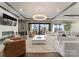 A bright living room features a large white sofa, marble coffee table, fireplace, and an outdoor balcony with scenic views at 19329 Watermark Dr # 551/552, Cornelius, NC 28031