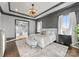 A luxury main bedroom boasts a tray ceiling, textured accent wall, and leads to a closet/sitting area at 19329 Watermark Dr # 551/552, Cornelius, NC 28031