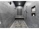 A modern shower boasts dual shower heads, dark-colored tile surround, and built-in shelving for toiletries at 19329 Watermark Dr # 551/552, Cornelius, NC 28031