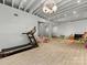 Finished basement area with a treadmill and plenty of room for activities, featuring a ceiling chandelier at 2109 Wellesley Ave, Charlotte, NC 28207