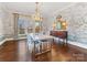 Elegant dining room boasts decorative wallpaper, a dazzling chandelier and beautiful hardwood floors at 2109 Wellesley Ave, Charlotte, NC 28207