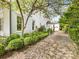 Charming white brick home exterior with a tree-lined brick driveway and manicured landscaping at 2109 Wellesley Ave, Charlotte, NC 28207