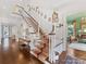 Elegant staircase with white railings and a patterned runner, complemented by wood floors and decor at 2109 Wellesley Ave, Charlotte, NC 28207
