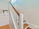 A bright stairwell features hardwood steps, white wooden handrails, and clean, neutral wall colors at 2109 Wellesley Ave, Charlotte, NC 28207