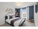 Stylish bedroom featuring a bed, bedside table, and accent wall at 2230 Cobble Ct # 154, Monroe, NC 28110