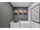 Well-equipped laundry room featuring modern washer, dryer, storage baskets, and stylish decor at 2241 Cobble Ct # 221, Monroe, NC 28110