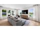 Inviting living room with a gray sectional sofa, large windows, and sleek modern entertainment center at 2243 Cobble Ct # 222, Monroe, NC 28110