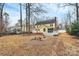 Large backyard with a yellow home, a deck, and many trees at 2321 Heathershire Ln, Matthews, NC 28105