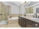 Bathroom features tiled walls and floors, double sink vanity, soaking tub and tiled shower at 2321 Heathershire Ln, Matthews, NC 28105