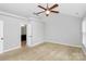Spacious bedroom with neutral carpet, ceiling fan and a door to the bathroom at 2321 Heathershire Ln, Matthews, NC 28105