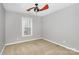 Cozy bedroom with neutral carpet, ceiling fan, and bright window overlooking the yard at 2321 Heathershire Ln, Matthews, NC 28105