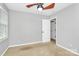 Cozy bedroom with neutral carpet, ceiling fan, window and a door to another room at 2321 Heathershire Ln, Matthews, NC 28105