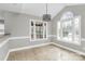 Bright dining area features large windows, stylish chandelier, and neutral tile flooring at 2321 Heathershire Ln, Matthews, NC 28105