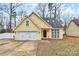 Charming yellow single-story home featuring an attached garage and well-maintained front yard at 2321 Heathershire Ln, Matthews, NC 28105