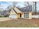 Lovely yellow home with a white garage door, large windows, and a cozy entrance at 2321 Heathershire Ln, Matthews, NC 28105