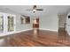 Spacious living room with hardwood floors and ceiling fan, seamlessly connecting to the modern kitchen at 2321 Heathershire Ln, Matthews, NC 28105