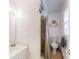 Compact bathroom featuring a shower with tile walls, toilet, sink, and storage shelves at 2360 Kings Grant Rd, Lincolnton, NC 28092