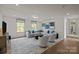 Comfortable living room with a large gray sectional, gray rug, and natural light from the windows at 281 Supernova Dr, York, SC 29745