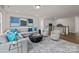 Bright living room with a gray sectional, two chairs, a modern rug and view to a staircase at 281 Supernova Dr, York, SC 29745