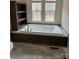 Bathroom featuring a soaking tub with windows, dark wood cabinets, and shelving for a luxurious touch at 339 Pine Lake Dr # 760, Troy, NC 27371