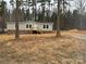 Inviting single-story home featuring light siding, brick foundation, and a serene wooded backdrop at 339 Pine Lake Dr # 760, Troy, NC 27371