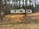 Charming ranch home with neutral siding, brick foundation, wooden deck, and a backdrop of tall trees at 339 Pine Lake Dr # 760, Troy, NC 27371
