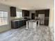 Modern kitchen with dark wood cabinets, stainless steel appliances, a large island, and light colored flooring at 339 Pine Lake Dr # 760, Troy, NC 27371