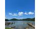 Scenic lake view showcasing docks and waterfront access under a clear blue sky with clouds at 339 Pine Lake Dr # 760, Troy, NC 27371
