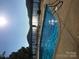 Community pool with lake views and lounge chairs along the deck on a sunny day at 339 Pine Lake Dr # 760, Troy, NC 27371