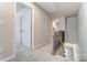 Upstairs hallway with doors, gray carpet, and a staircase at 4102 Cheyney Park Dr, Charlotte, NC 28269