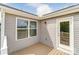 View of the private patio showing a glass door entrance, gray siding, and wood flooring at 4102 Cheyney Park Dr, Charlotte, NC 28269