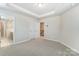 Bedroom features neutral carpet, a tray ceiling, and an open doorway to the bathroom at 4118 Cheyney Park Dr, Charlotte, NC 28269