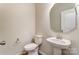 Powder room with pedestal sink, toilet, and decorative mirror at 4118 Cheyney Park Dr, Charlotte, NC 28269
