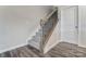 Carpeted staircase with decorative black iron railings and wood banister, adjacent to a white door at 4118 Cheyney Park Dr, Charlotte, NC 28269