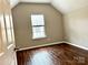 Bedroom features neutral paint, hardwood floors, base molding, and a window for natural light at 4809 Canipe Dr, Charlotte, NC 28269