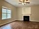 Bright living room with a fireplace, hardwood floors, and a ceiling fan at 4809 Canipe Dr, Charlotte, NC 28269