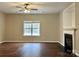 Bright living room featuring a fireplace, hardwood floors, a ceiling fan, and a large window at 4809 Canipe Dr, Charlotte, NC 28269