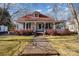 Charming home with a red roof, white siding, and a welcoming front porch, surrounded by lush greenery at 517 Stockton St, Statesville, NC 28677