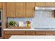 Well-organized kitchen featuring tan cabinetry, marble tile backsplash, and modern stainless steel appliances at 5911 Wetlands Aly, Charlotte, NC 28215