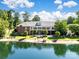 Expansive aerial view of a brick estate with a private lake, lush landscaping, and outdoor seating areas at 6823 Manatee Dr, Concord, NC 28025
