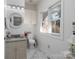 Bright bathroom featuring granite counters, storage, round mirror and a window providing natural light at 6823 Manatee Dr, Concord, NC 28025