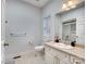 Clean bathroom with a white vanity, tile floor, and a large window at 6823 Manatee Dr, Concord, NC 28025