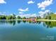 Stunning exterior view of a lakeside brick home with lush trees and a serene waterfront at 6823 Manatee Dr, Concord, NC 28025