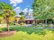 Exterior view featuring a lush green lawn, mature palm trees, and a spacious brick building at 6823 Manatee Dr, Concord, NC 28025
